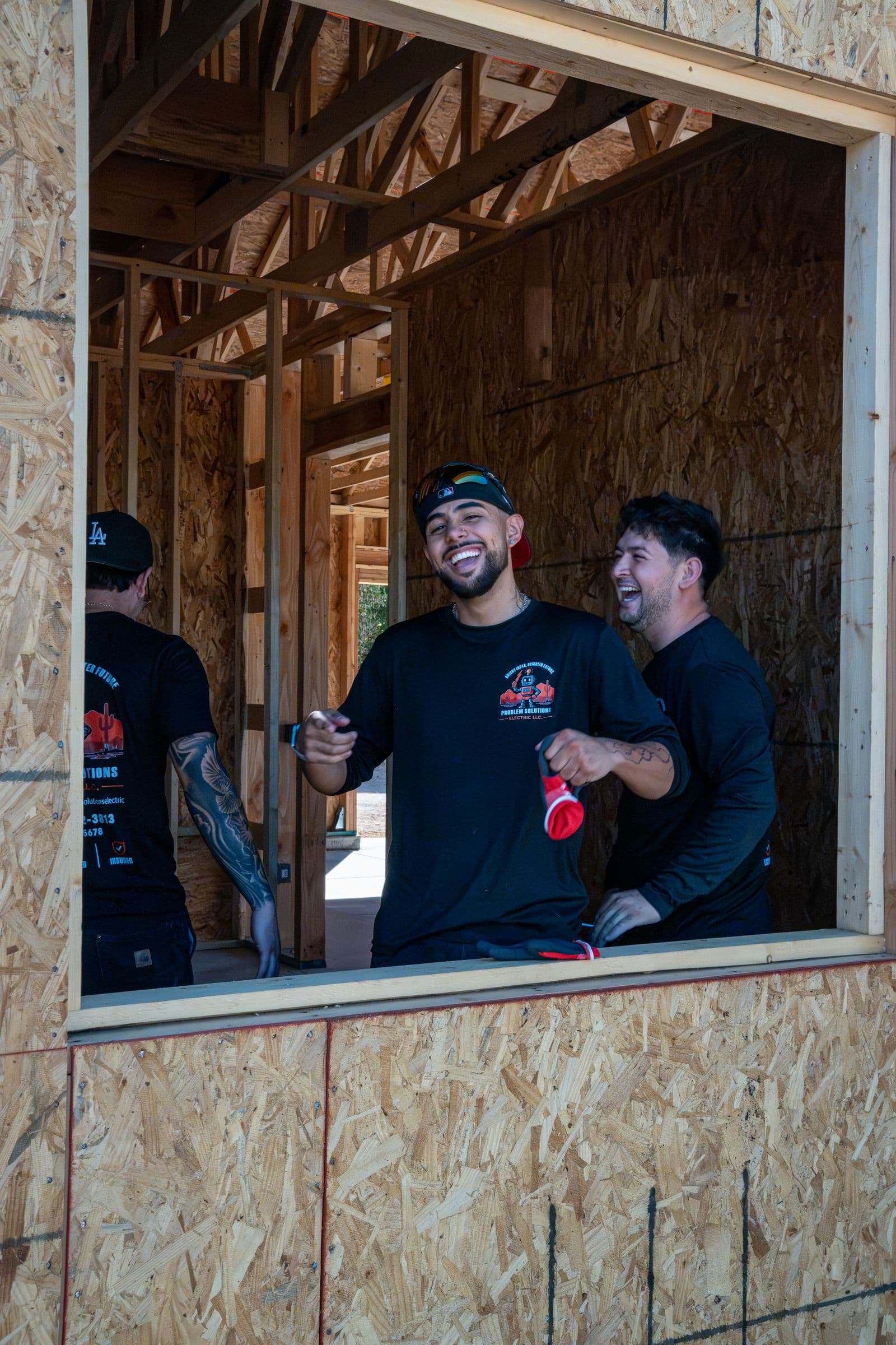 Two Problem Solutions Electric techs laughing through a framed window opening on a home they are wiring
