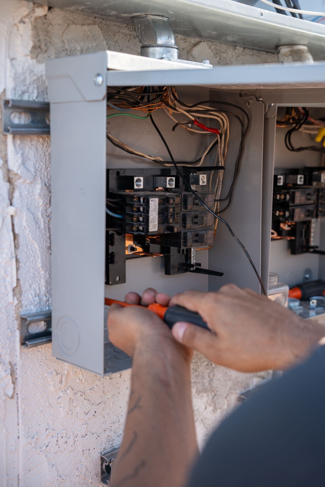 Hands with a screwdriver inside an open panel